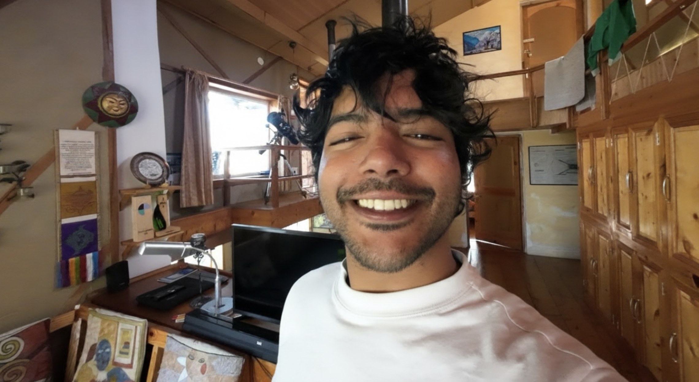 Aerathe Rajeev Nair smiling, in a sunlit wooden room